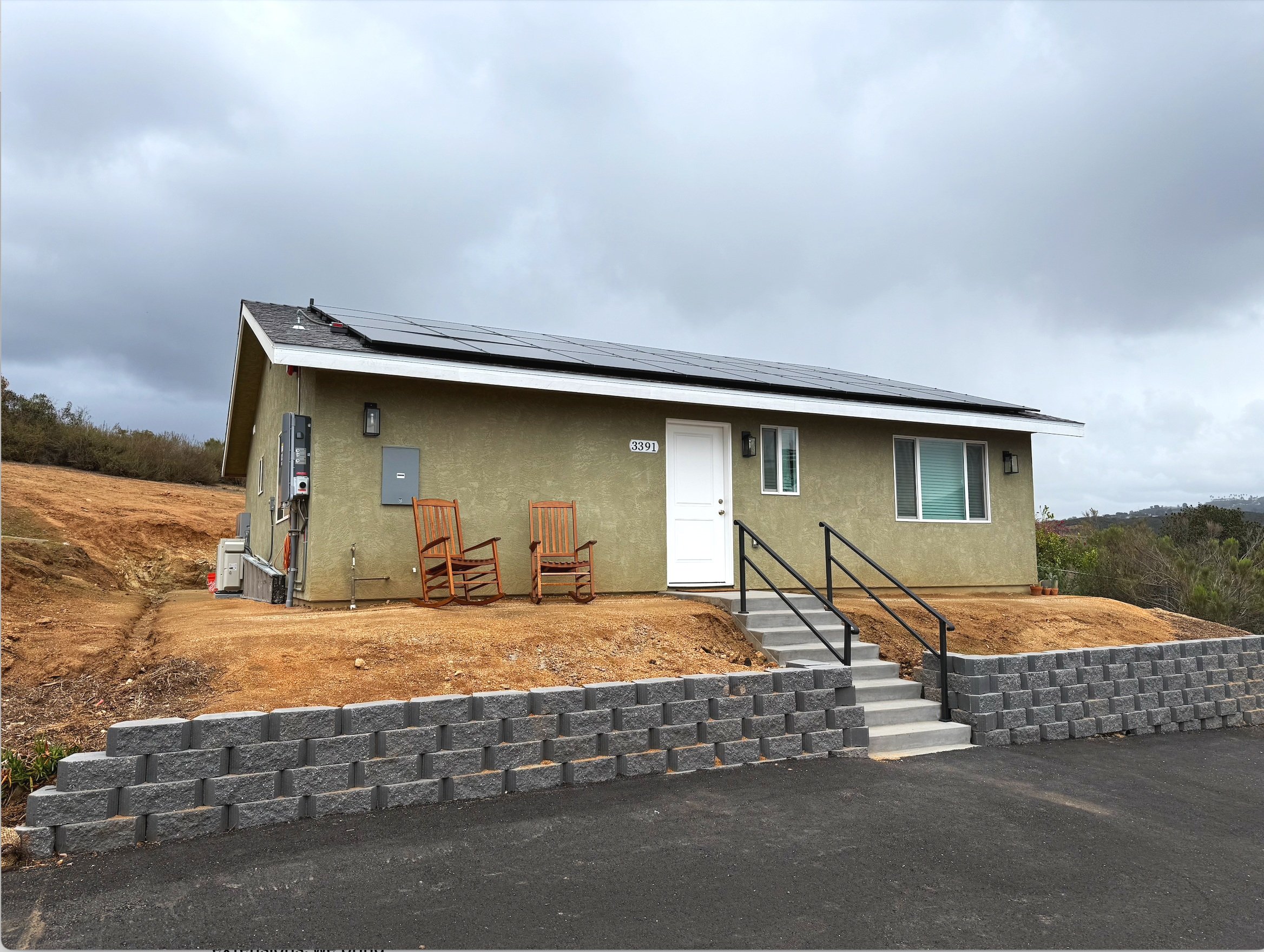 ADU exterior with solar panels and retaining wall