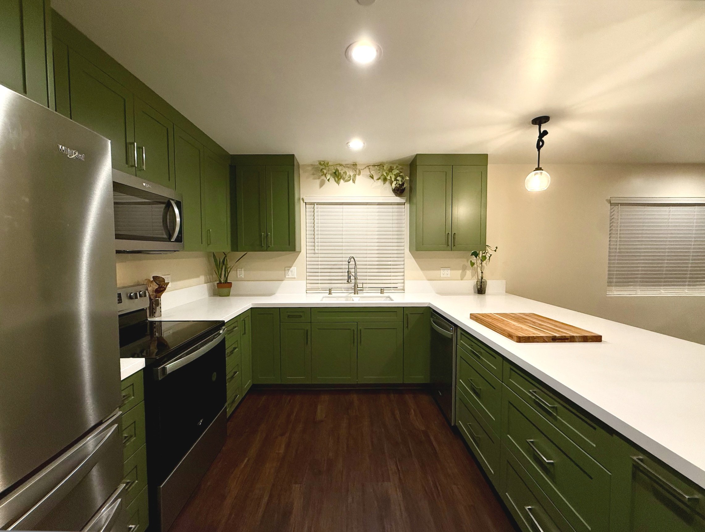 Modern kitchen remodel with green cabinets and white countertops